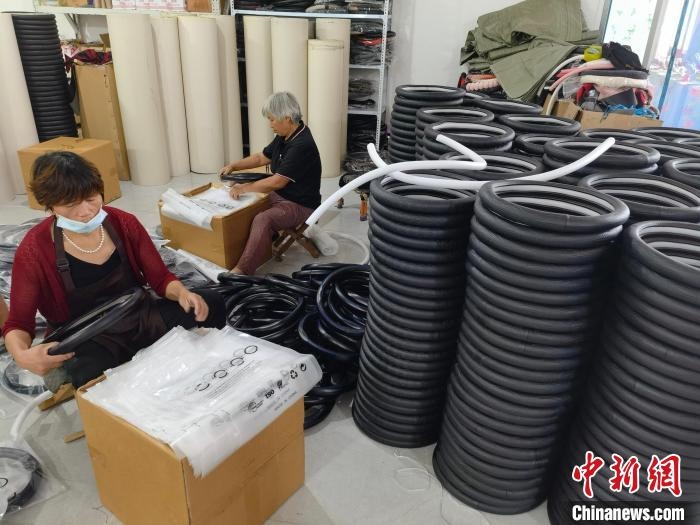 圖為村民在汽車飾品企業(yè)生產(chǎn)車間中工作?！巫雍?攝