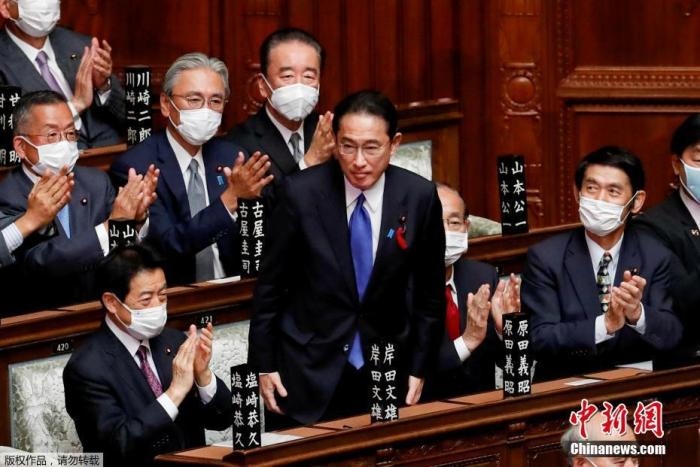 當?shù)貢r間10月4日，日本自民黨總裁岸田文雄經(jīng)過眾院全體會議的首相指名選舉成為第100任首相。圖為岸田文雄（中）起身致謝。