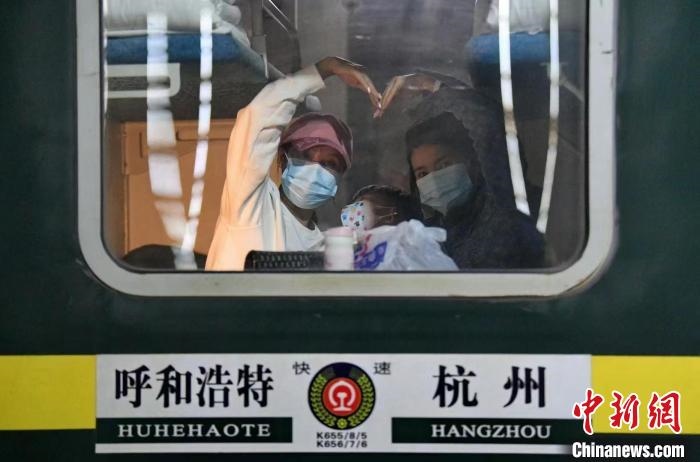 圖為登上轉(zhuǎn)運火車的游客向額濟納比心。　王磊 攝