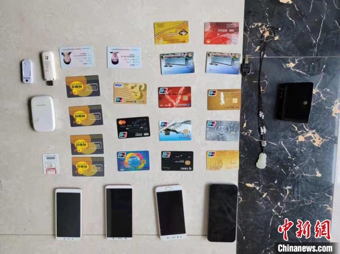 資料圖為果洛藏族自治州公安民警查扣的作案手機和涉案銀行卡?！‖斍呖h公安局供圖