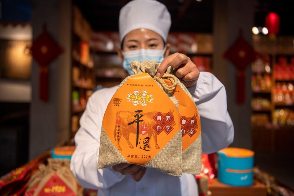1月27日，在平遙古城南大街的一家平遙牛肉店內(nèi)，工作人員展示一款牛肉產(chǎn)品。新華社記者 楊晨光 攝