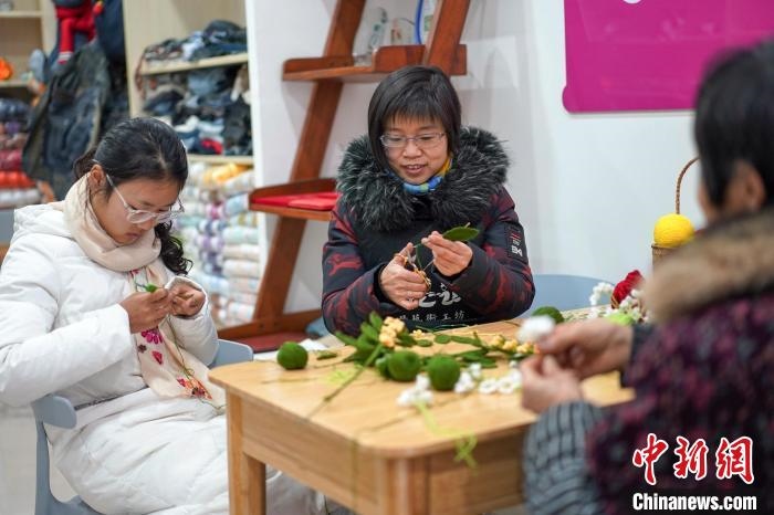 文創(chuàng)工作室的姐妹們正在鉤織月桂葉片。　古良駒 攝