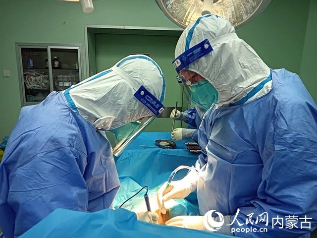 醫(yī)護(hù)人員正在為新冠肺炎合并腸梗阻腸穿孔的尿毒癥患者實(shí)施急診手術(shù)。呼和浩特市第一醫(yī)院供圖