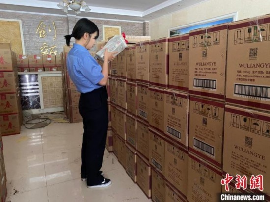 資料圖為檢察人員核對查獲的假冒品牌白酒。青海省人民檢察院供圖