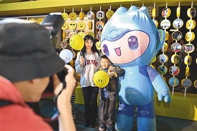 5月7日，在浙江省杭州市湖濱步行街“3D笑臉墻”前，攝影師為游客與杭州亞運會吉祥物之一“宸宸”拍攝合影。