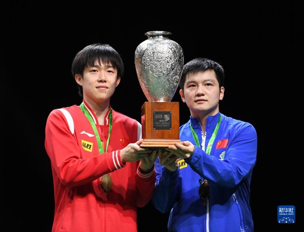 5月27日，樊振東（右）/王楚欽在頒獎(jiǎng)儀式上高舉獎(jiǎng)杯慶祝。當(dāng)日，在南非德班進(jìn)行的2023年世界乒乓球錦標(biāo)賽男雙決賽中，中國(guó)組合樊振東/王楚欽以3比0戰(zhàn)勝韓國(guó)組合張禹珍/林鐘勛，奪得冠軍。新華社記者 李亞輝攝