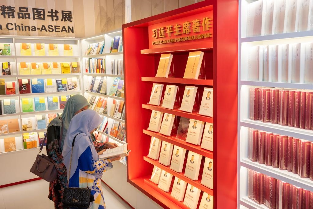5月30日，兩名讀者在馬來西亞吉隆坡國際書展中國主賓國活動現(xiàn)場閱讀習(xí)近平主席著作。新華社記者朱煒攝