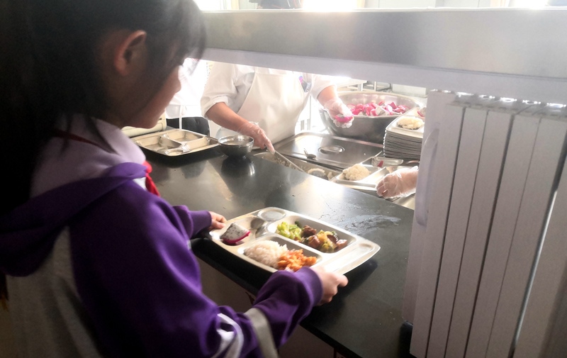 伊金霍洛旗第一小學(xué)學(xué)生正在打飯，今天的飯菜是三菜一湯外加水果，學(xué)生可以多次盛取，吃飽為止。人民網(wǎng)記者 孫博洋攝