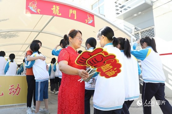 6月7日一早，雄安新區(qū)安新中學(xué)老師在給同學(xué)們加油鼓勁兒。人民網(wǎng) 李兆民攝