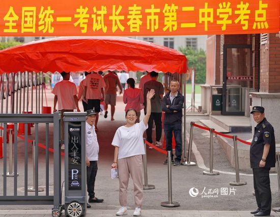 6月7日，在長春市第二中學(xué)考點(diǎn)，一名考生信心滿滿進(jìn)入考場，并與家長揮手致意。人民網(wǎng)記者 李洋攝