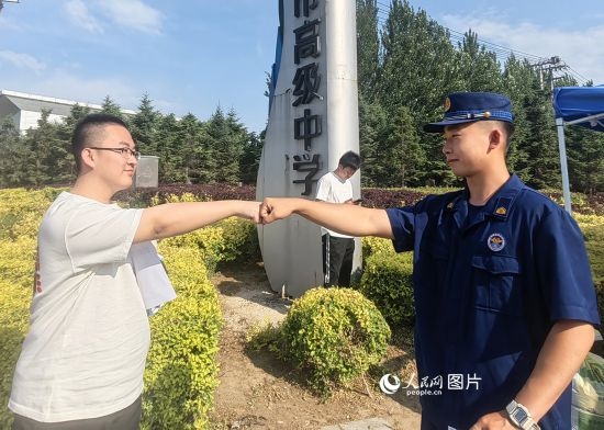 6月7日，遼寧營口老邊區(qū)消防救援大隊的消防員為高考學(xué)子加油助威。人民網(wǎng)記者 尹柏寒?dāng)z