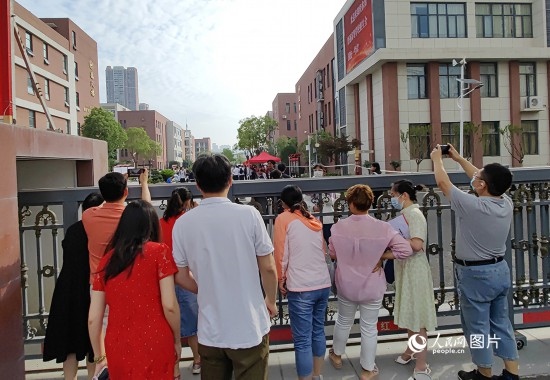 6月7日，武漢市第三中學(xué)考點(diǎn)，考生進(jìn)場后，家長在柵欄外用手機(jī)拍攝自己的孩子。人民網(wǎng)記者 郭婷婷攝