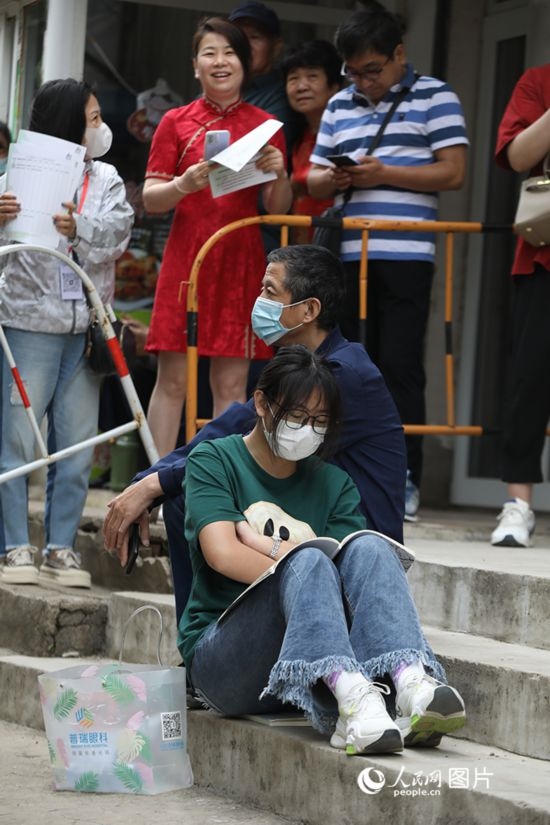 6月7日，沈陽市第一中學(xué)，學(xué)子靠在父親身邊做最后的沖刺。人民網(wǎng) 周頌雪攝