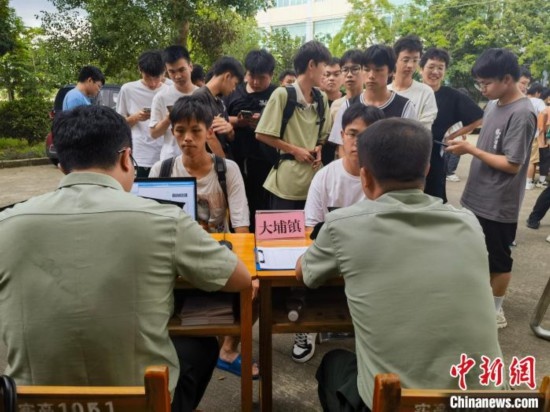 專武干部在發(fā)放兵役登記證。韋碩 攝