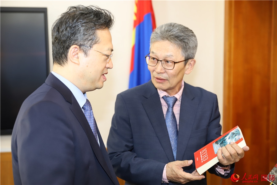 其米德策耶（右一）向李峙介紹翻譯成果。人民網記者 霍文攝