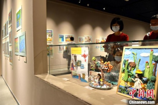 圖為家長(zhǎng)帶著孩子參觀展覽。呂明 攝