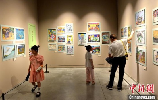 圖為家長(zhǎng)帶著孩子參觀展覽。呂明 攝
