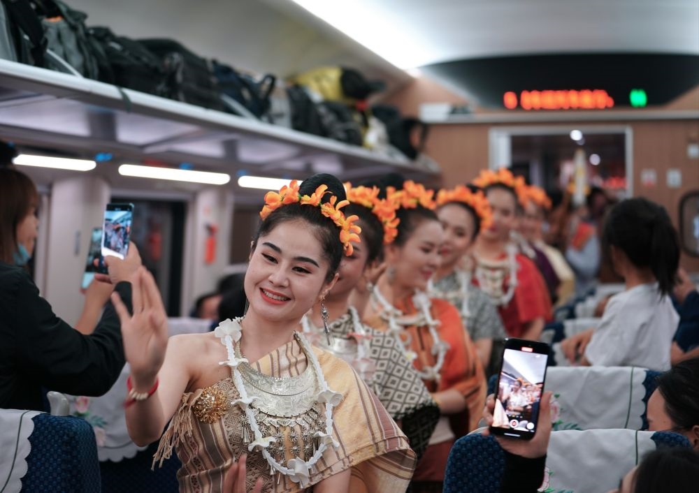 2023年4月13日，老撾工作人員在D887次國際旅客列車上表演。當(dāng)日，中老鐵路從中國昆明南站、老撾萬象站雙向?qū)﹂_D887次和D888次國際旅客列車，兩地乘火車可當(dāng)日通達(dá)。中老鐵路是高質(zhì)量共建“一帶一路”的標(biāo)志性工程。新華社記者 邢廣利 攝