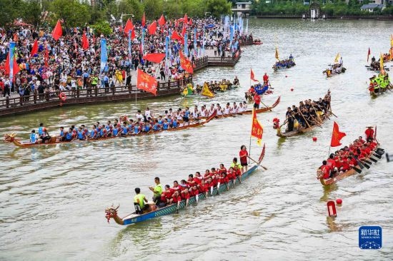 6月23日，在貴州省黔東南苗族侗族自治州施秉縣舉行的獨(dú)木龍舟節(jié)上，獨(dú)木龍舟進(jìn)行水上巡游。