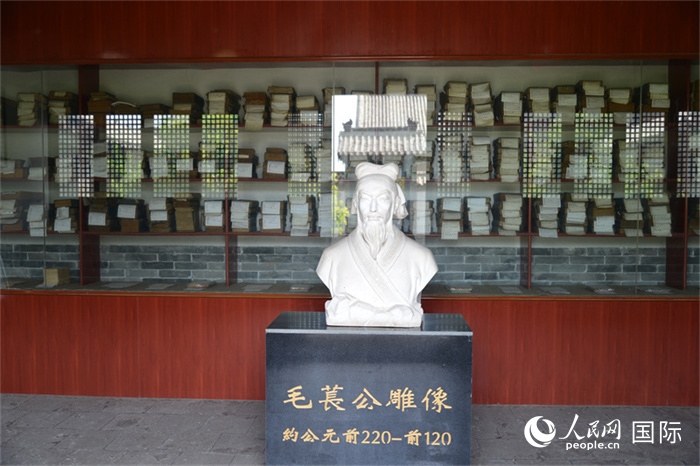 河間詩經(jīng)齋毛萇雕像。雕像后書櫥中陳列的是歷代各版本《詩經(jīng)》及譯本。 人民網(wǎng) 趙昭攝