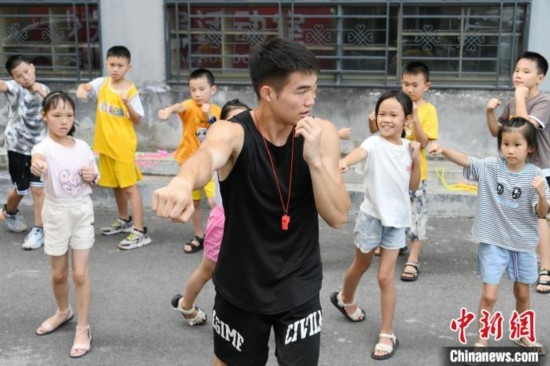 圖為大學(xué)生志愿者在組織孩子們參加體育健身活動(dòng)。廖光福 攝