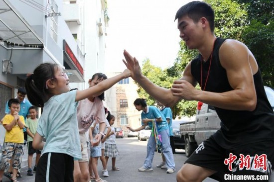 圖為大學(xué)生志愿者在組織孩子們參加體育健身活動(dòng)。廖光福 攝