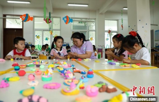 在肥西縣山南鎮(zhèn)中心幼兒園，孩子們在老師的指導下做彩色泥塑。陳家樂 攝