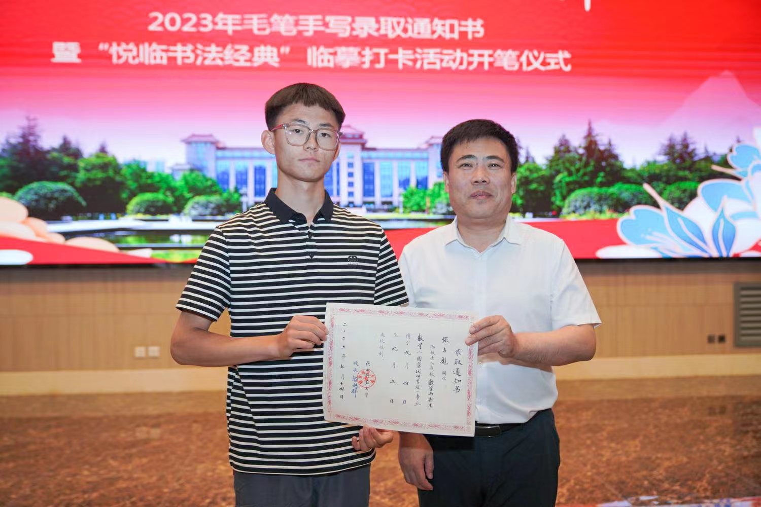 陜西師范大學(xué)黨委書記李忠軍為2023級新生代表張占彪同學(xué)發(fā)放錄取通知書。校方供圖