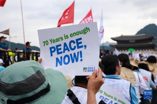 7月22日，在韓國首爾，人們手舉標(biāo)語參與反戰(zhàn)游行。新華社發(fā)（楊暢 攝）
