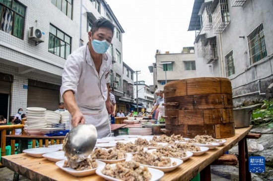 7月29日，在重慶市綦江區(qū)安穩(wěn)鎮(zhèn)，當?shù)鼐用裨凇懊缂曳蚬?jié)”上準備羊肉長桌宴。新華社記者 唐奕 攝