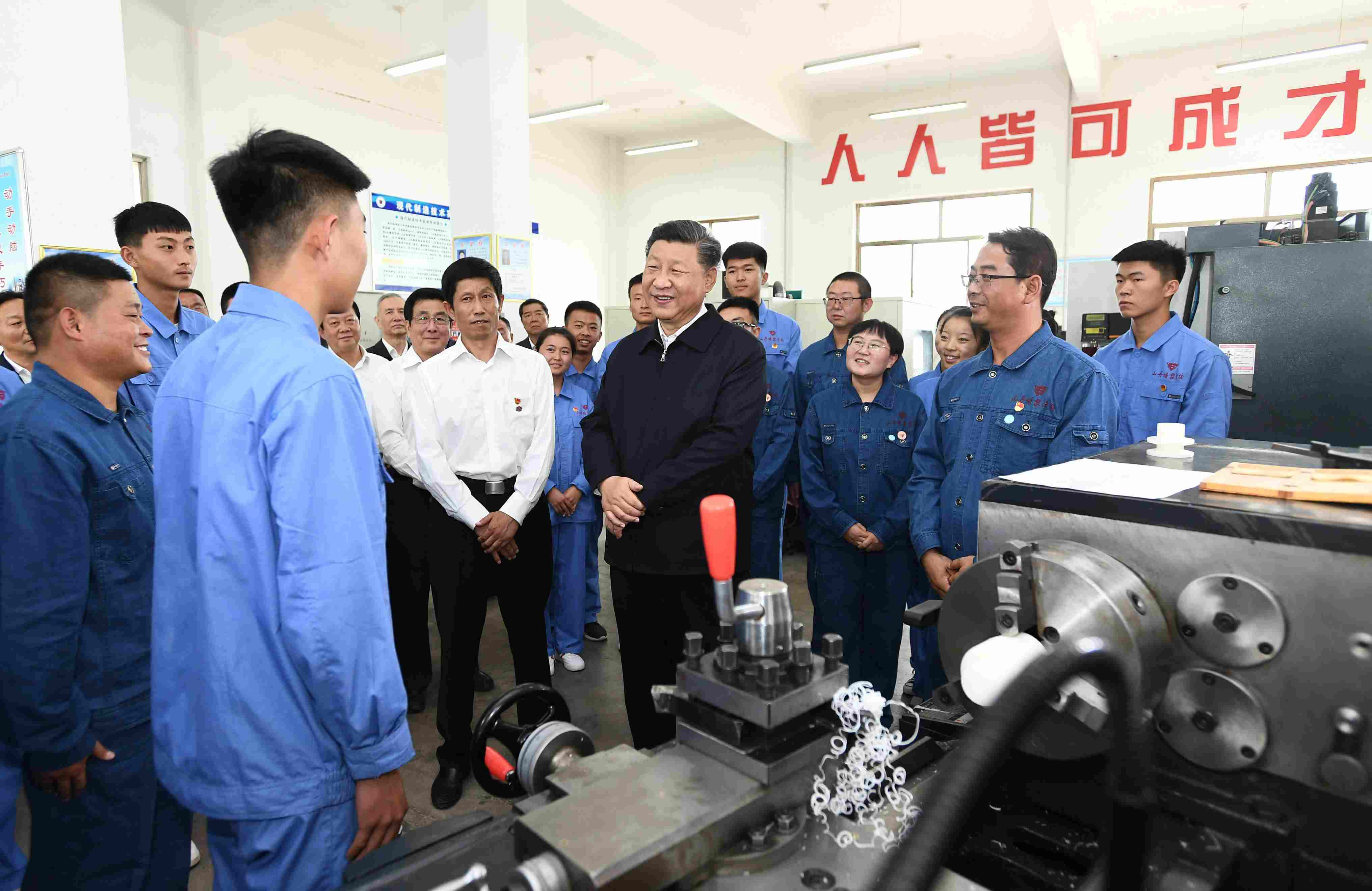 2019年8月20日，習(xí)近平在甘肅省張掖市山丹培黎學(xué)校現(xiàn)代制造技術(shù)實(shí)訓(xùn)室，觀看職業(yè)技能實(shí)訓(xùn)，同師生親切交流。