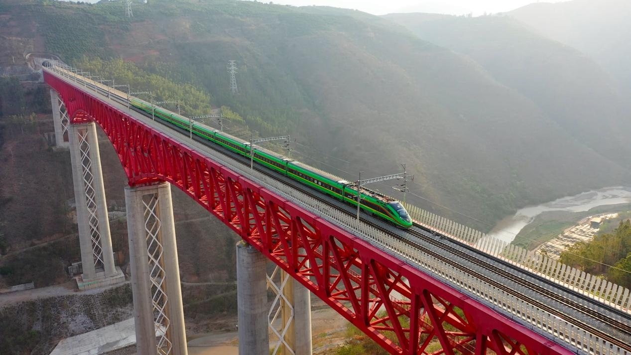 中老鐵路國(guó)際旅客列車在云南省境內(nèi)的元江特大橋上飛馳。姚巍攝