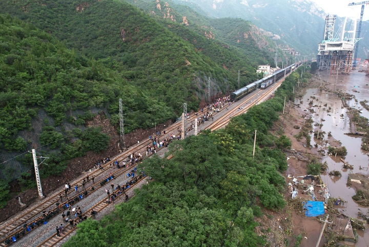 8月2日，受困列車旅客在救援人員幫助下徒步趕往轉(zhuǎn)運(yùn)客車（無人機(jī)照片）。新華社記者 張晨霖 攝
