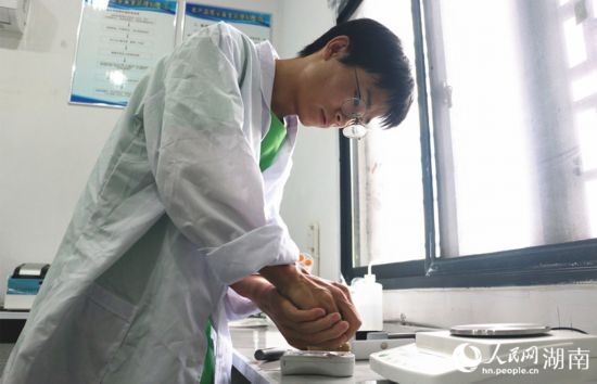 吳健筆在獼猴桃科技小院實驗室測量水果糖分。 人民網(wǎng)記者 劉賓攝