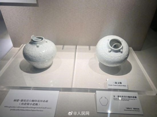 福建德化窯白釉印花四系罐（左）。人民網記者 李娜攝