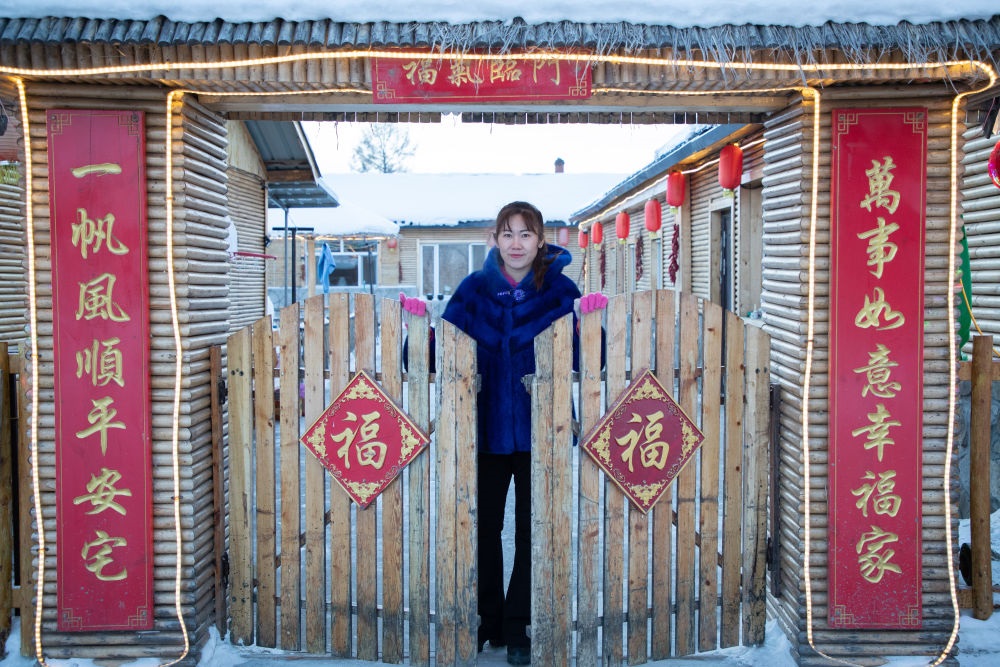 北極村民宿經(jīng)營(yíng)者史瑞娟在門(mén)前迎候入住的游客（2023年1月7日攝）。
