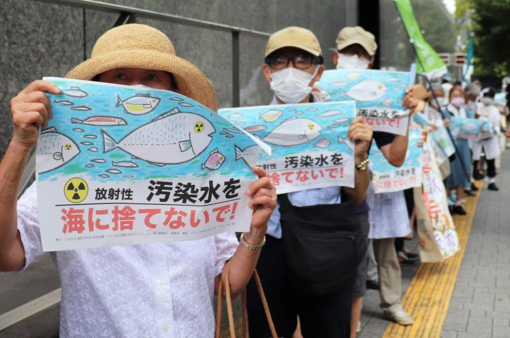 8月24日，日本民眾手持“不要將污染水扔進(jìn)大?！钡葮?biāo)語在東京電力公司總部前集會，抗議日本政府和東電公司無視民意啟動核污染水排海。新華社記者楊光攝