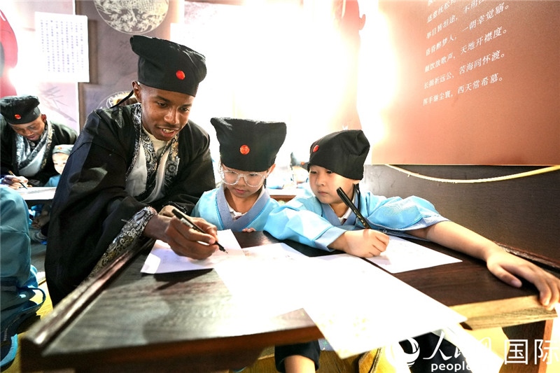 圖為選手與同學(xué)們一起寫書法。人民網(wǎng) 盧鵬宇攝