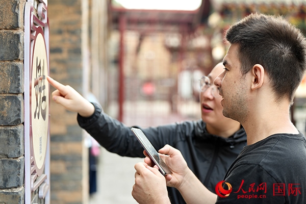 選手安德烈（俄羅斯）在老師指導(dǎo)下學(xué)習(xí)墻壁上張貼的生僻字。人民網(wǎng) 盧鵬宇攝