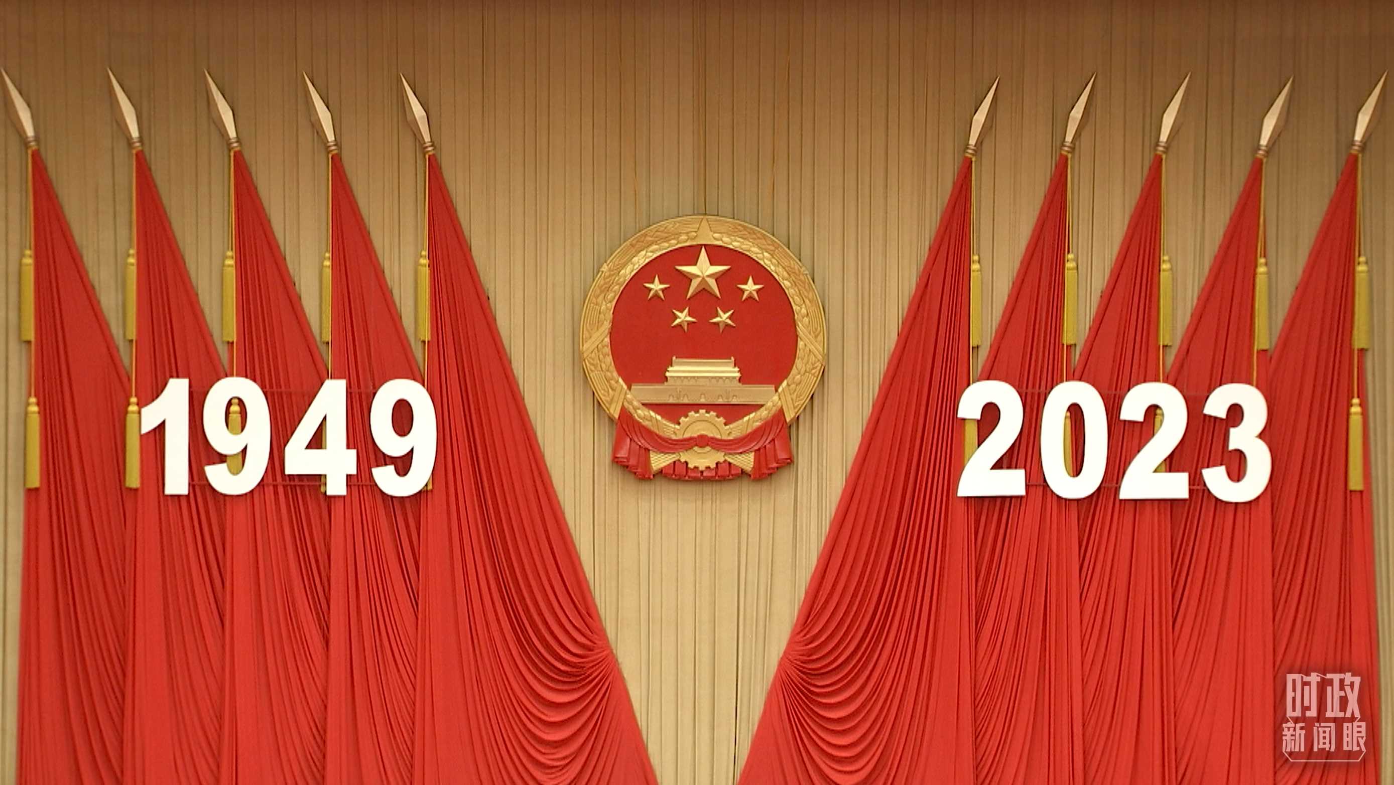 △人民大會堂宴會廳內(nèi)，主席臺上方高懸著莊嚴(yán)的國徽，“1949－2023”大字年號在鮮艷的紅旗映襯下格外醒目。
