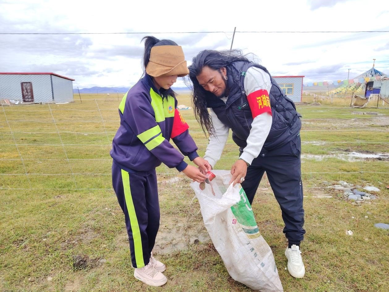 玉樹(shù)州稱多縣珍秦鎮(zhèn)河湖志愿者才培和他女兒更求拉毛在清掃垃圾。受訪者供圖
