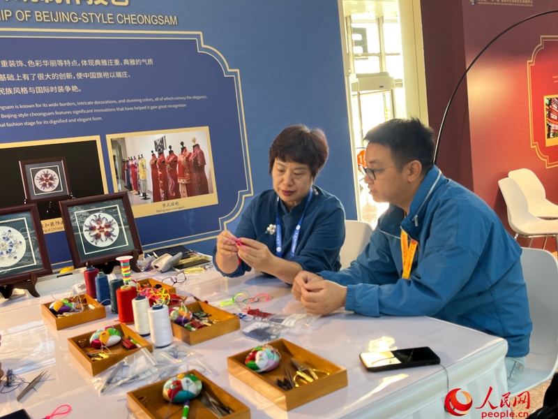 記者在新聞中心非遺傳承人展區(qū)進(jìn)行體驗(yàn)。人民網(wǎng)記者 杜燕飛攝