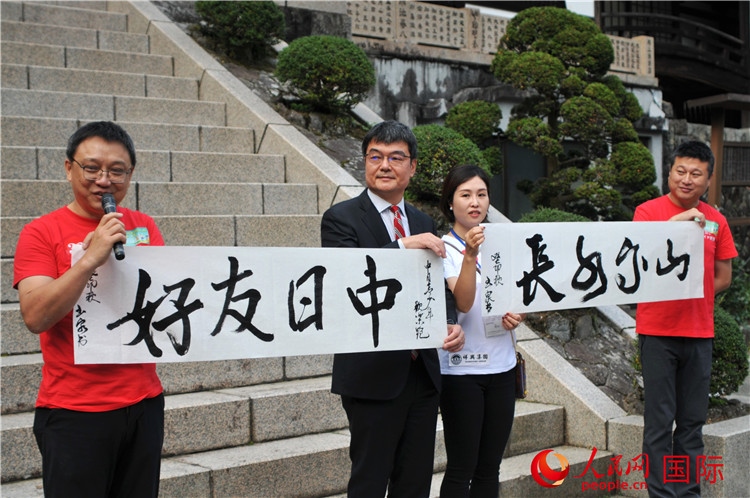 東京中國文化中心主任羅玉泉展示其為本次活動(dòng)書寫的題詞“中日友好，山高水長”。人民網(wǎng) 蔣曉辰攝