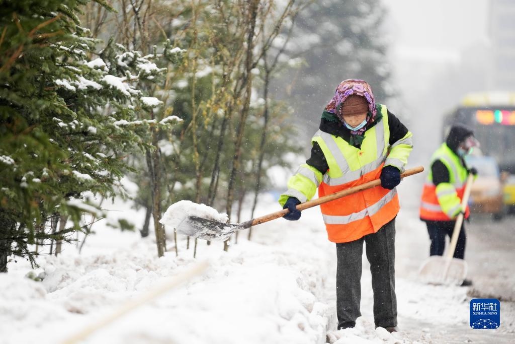 11月16日，環(huán)衛(wèi)工人在清理道路上的積雪。當(dāng)日，黑龍江哈爾濱市迎來雨雪天氣。新華社記者 王建威 攝