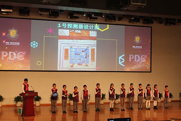 北京呼家樓中心小學(xué)的學(xué)生們展示PDC項目“新行星移民計劃探索衛(wèi)星設(shè)計”。