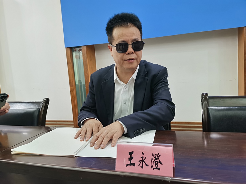 全國人大代表王永澄正在閱讀盲文版代表建議答復(fù)。本報(bào)記者 張 璁?dāng)z