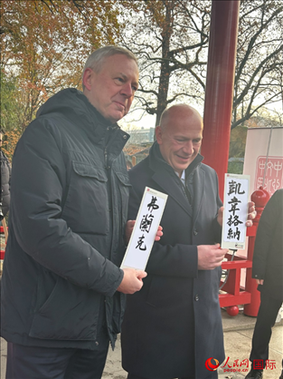 柏林市長(zhǎng)韋格納（右）、動(dòng)物園監(jiān)事會(huì)主席布魯克曼（左）手持中國(guó)文化中心工作人員現(xiàn)場(chǎng)手書的中文名字。人民網(wǎng)記者 徐馨攝