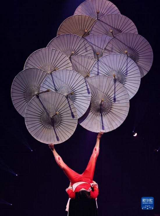 12月8日，演員在法國(guó)巴黎舉行的中國(guó)雜技“奇妙之夜”演出上表演《蹬傘》。新華社記者 高靜 攝