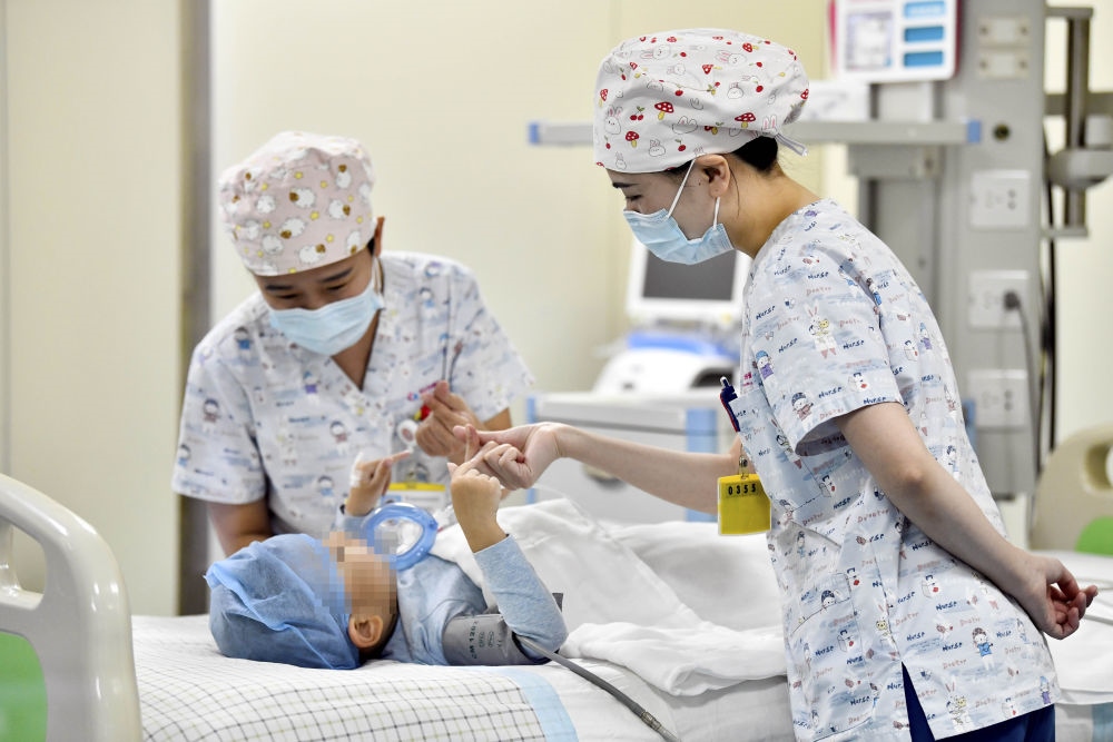 在山東省棗莊市婦幼保健院兒童ICU病房，醫(yī)護(hù)人員為完成靶向治療藥物諾西那生鈉的4歲脊髓性肌萎縮癥患兒加油鼓勁（2022年1月1日攝）。諾西那生鈉注射液是我國首個(gè)獲批治療脊髓性肌萎縮癥的進(jìn)口藥物，2019年進(jìn)入中國市場時(shí)，每針價(jià)格近70萬元。在2021年國家醫(yī)保目錄藥品談判中，以3.3萬元每針的價(jià)格進(jìn)入新版醫(yī)保藥品目錄。新華社記者 郭緒雷 攝