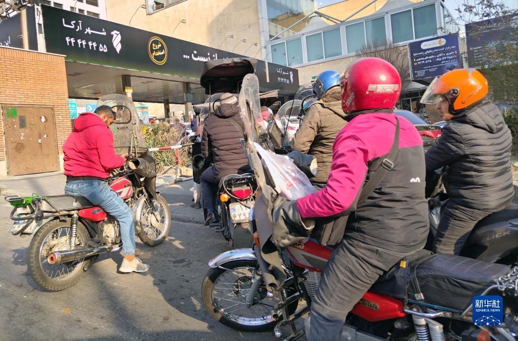 12月18日，摩托車在伊朗首都德黑蘭的一家加油站外等待加油。新華社記者 沙達(dá)提 攝